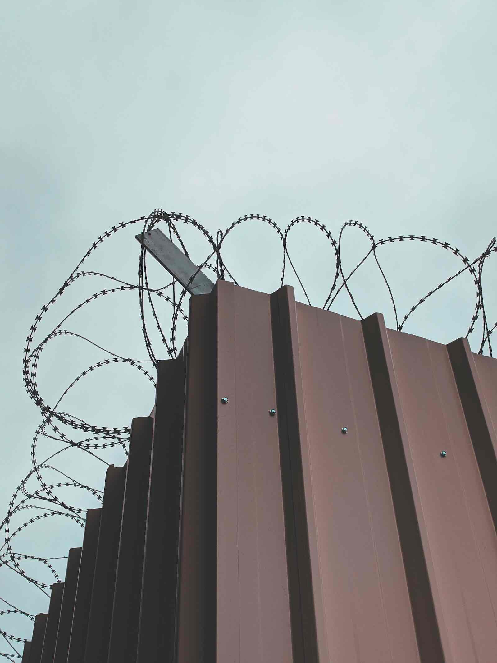Image of barbed wire above a metal wall