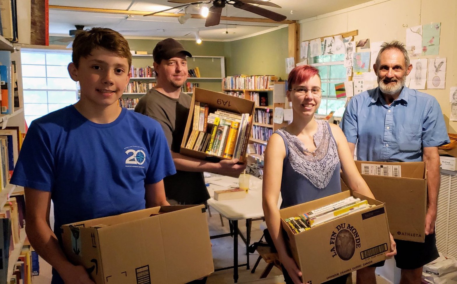 Volunteers showing off boxes of donated books.